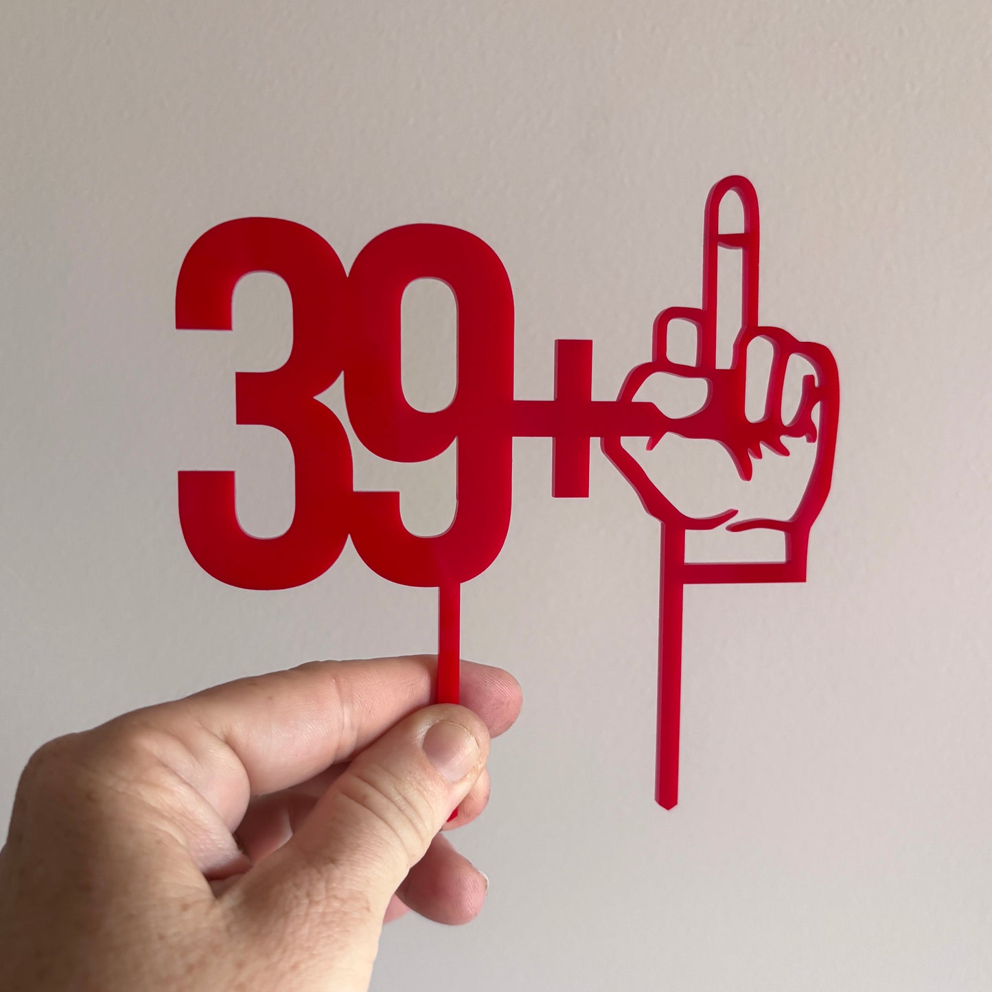 39 plus one cake topper being held on a white background.